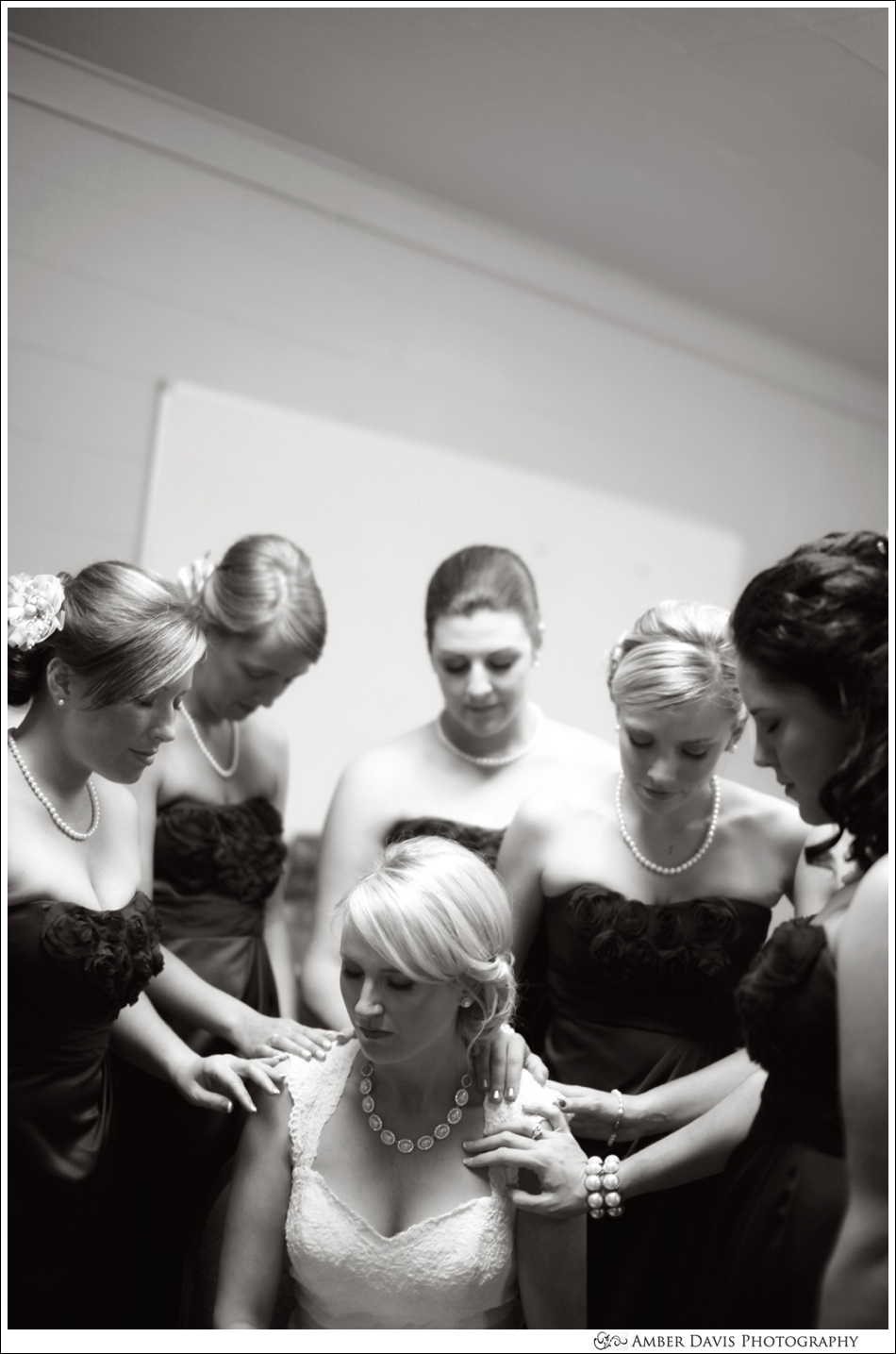 bridesmaids praying with bride