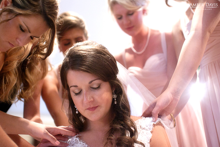 bridesmaids praying with bride