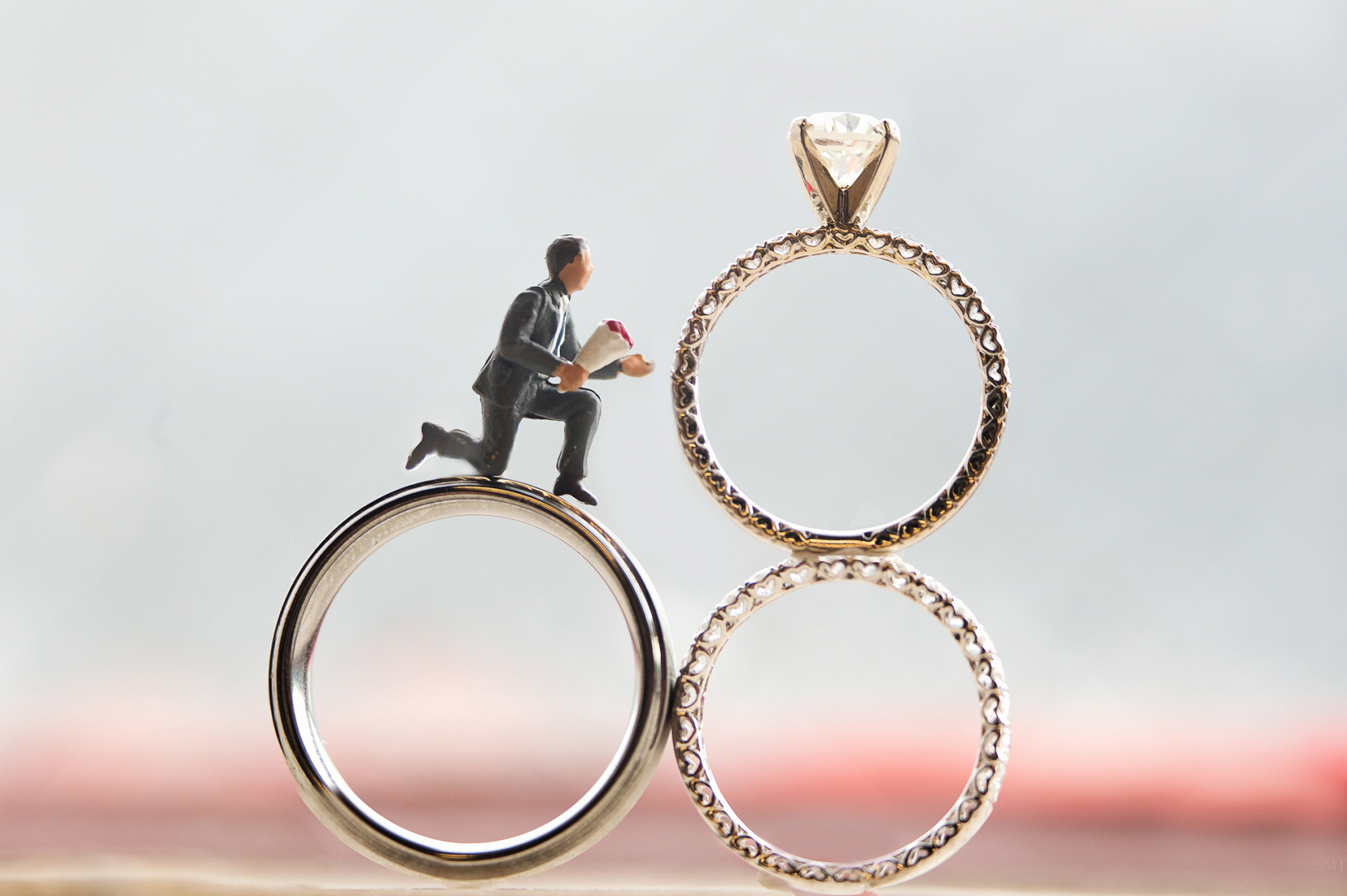 Tiny figurine on wedding rings proposing